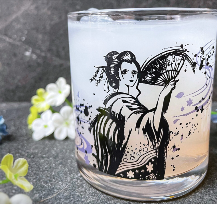 A glass with Nami from One Piece holding a fan and flowers in the background