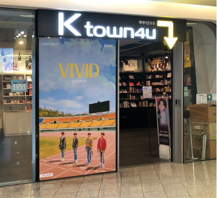 Ktown4u store with neon lights and poster for "Vivid" comeback