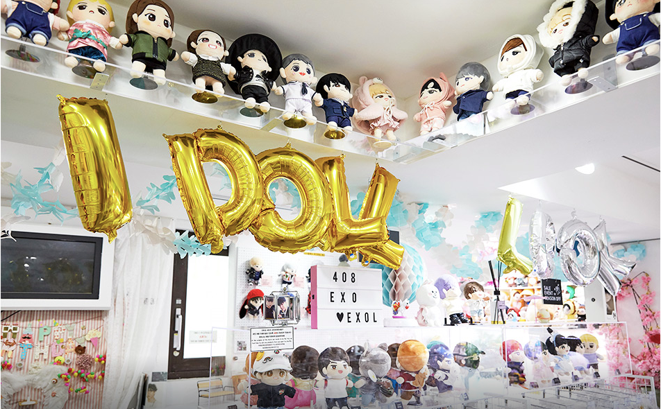 Kpop doll display and "I DOLL" gold balloon letters