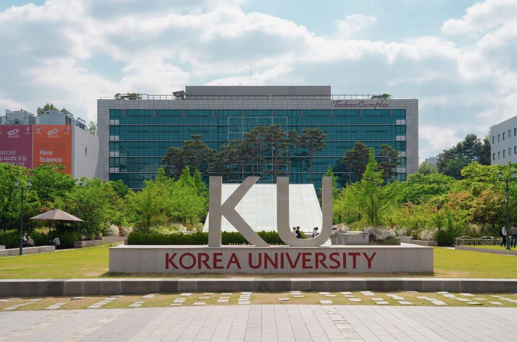 Korea University sign in front of wide skyscraper with blue windows