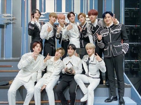 Eleven boys in black and/or white holding a crystal trophy