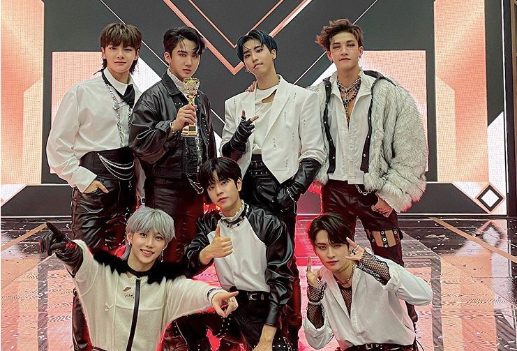 Seven boys in white shirts posing with crystal trophy