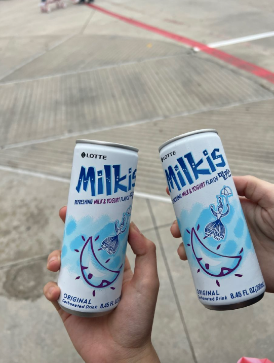 Two hands holding Milkis bottles