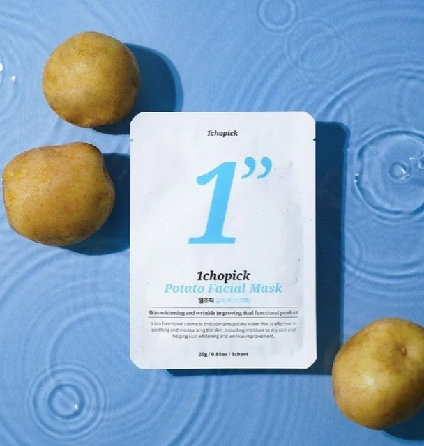 A white 1chopick face mask with three potatoes on a blue surface