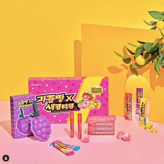 Fruity chews in pink and purple boxes on a pink surface with a yellow background