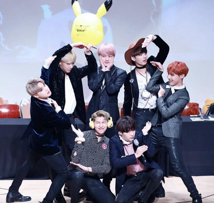 BTS posing with a giant Pikachu balloon