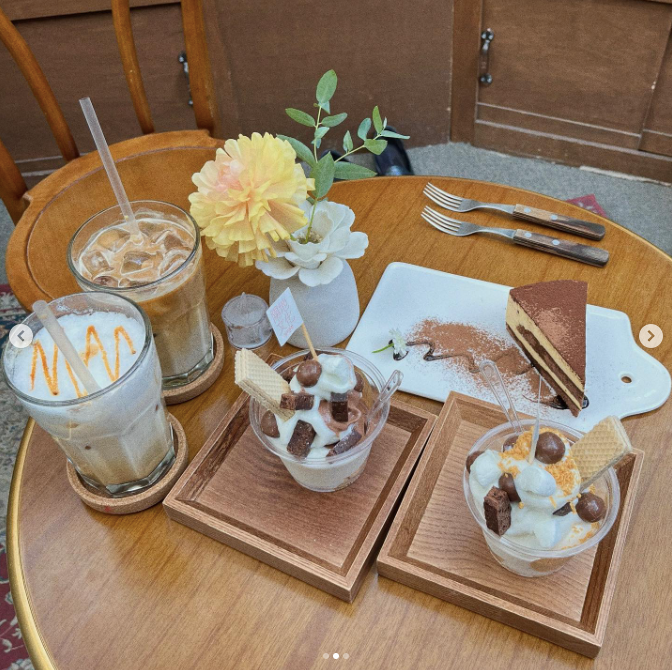 Two trays with parfaits, iced coffees, and yellow flowers