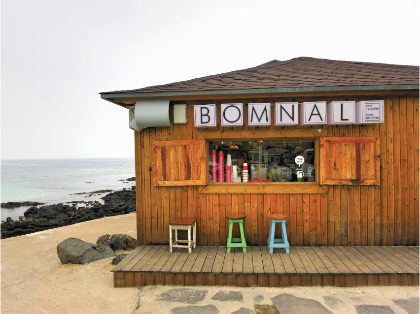 Exterior of Bomnal Cafe in Jeju with three stools on porch