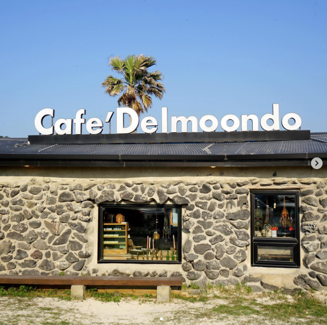 Exterior of Cafe Delmoondo with palm tree in the background