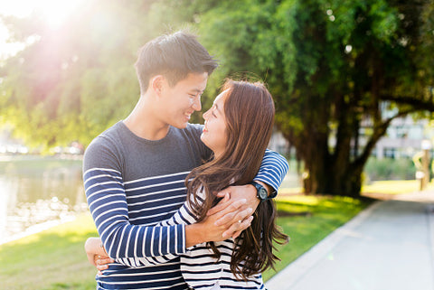 Smiling Korean couple hugging in park