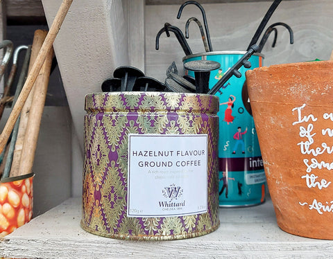 recycled coffee tin with old tent pegs inside a grey shed on a shelf