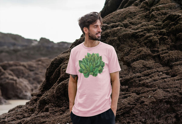man on a beach with pink t-shirt with a bright green succulent plant on it