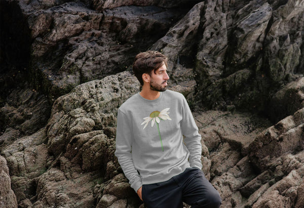 man on a beach with grey jumper with a white daisy echinacea plant on it