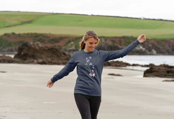 woman on a beach with blue jumper with pink sweet peas on it