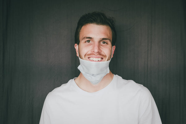 smiling man with his disposable face mask down to his chin