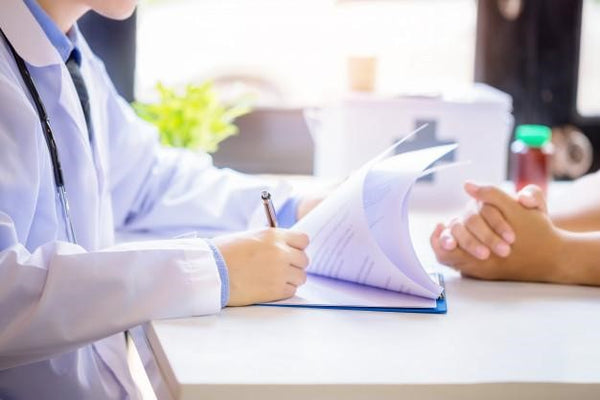 doctor writing down patient diagnosis on a paper