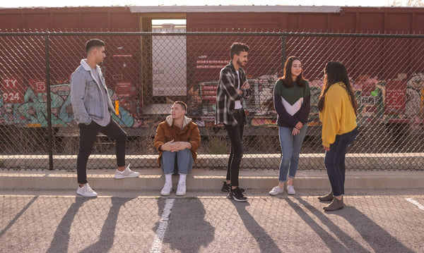 five teenagers talking and smiling