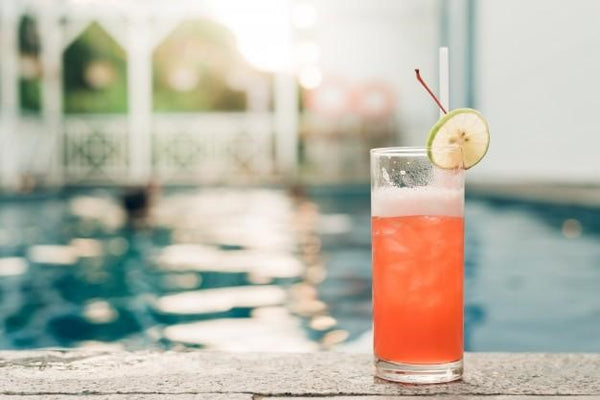 fruity ginseng punch in a glass with a swimming pool background