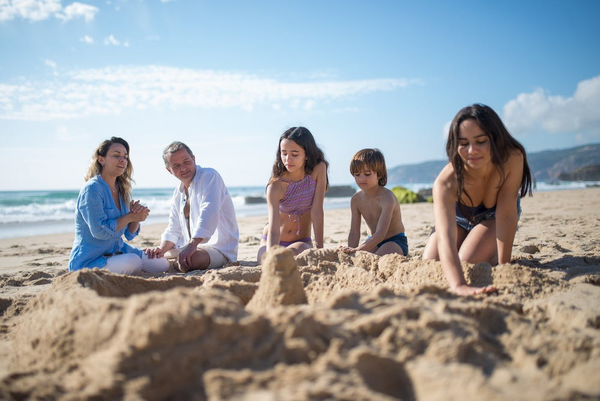 parents with three kids playing on the beach.png