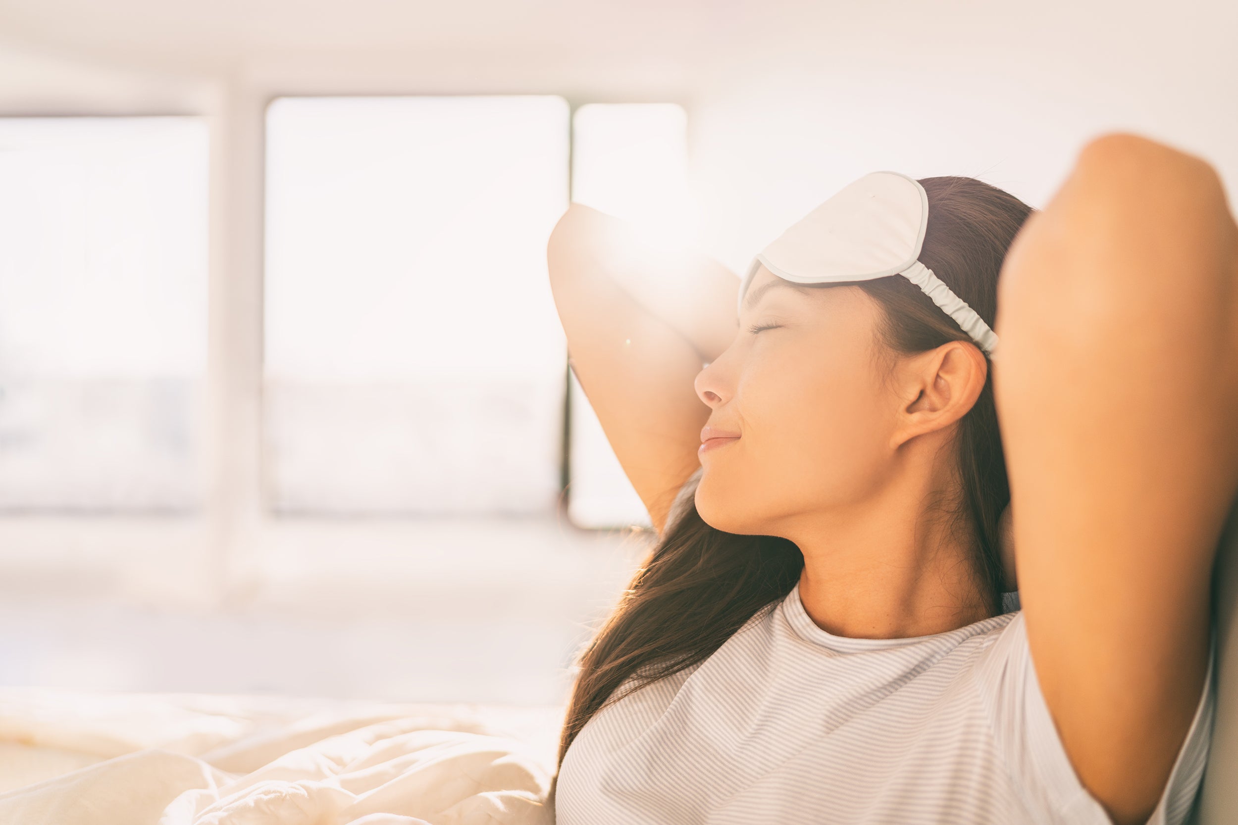 A woman appears well rested upon waking. A sleep apnea pillow that supports the whole body can have a powerful impact on not just sleep but overall wellness.