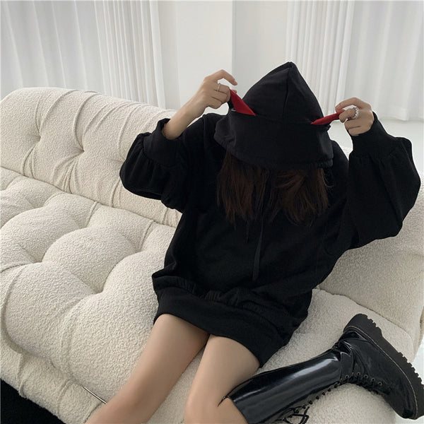 a young lady wearing a black color warm hoodie with red cat ears from meowgicians