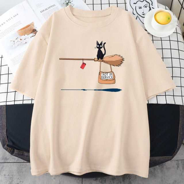 beige color t shirt printed with a little black cat sitting on a broom with a hanging bag written with not in service words