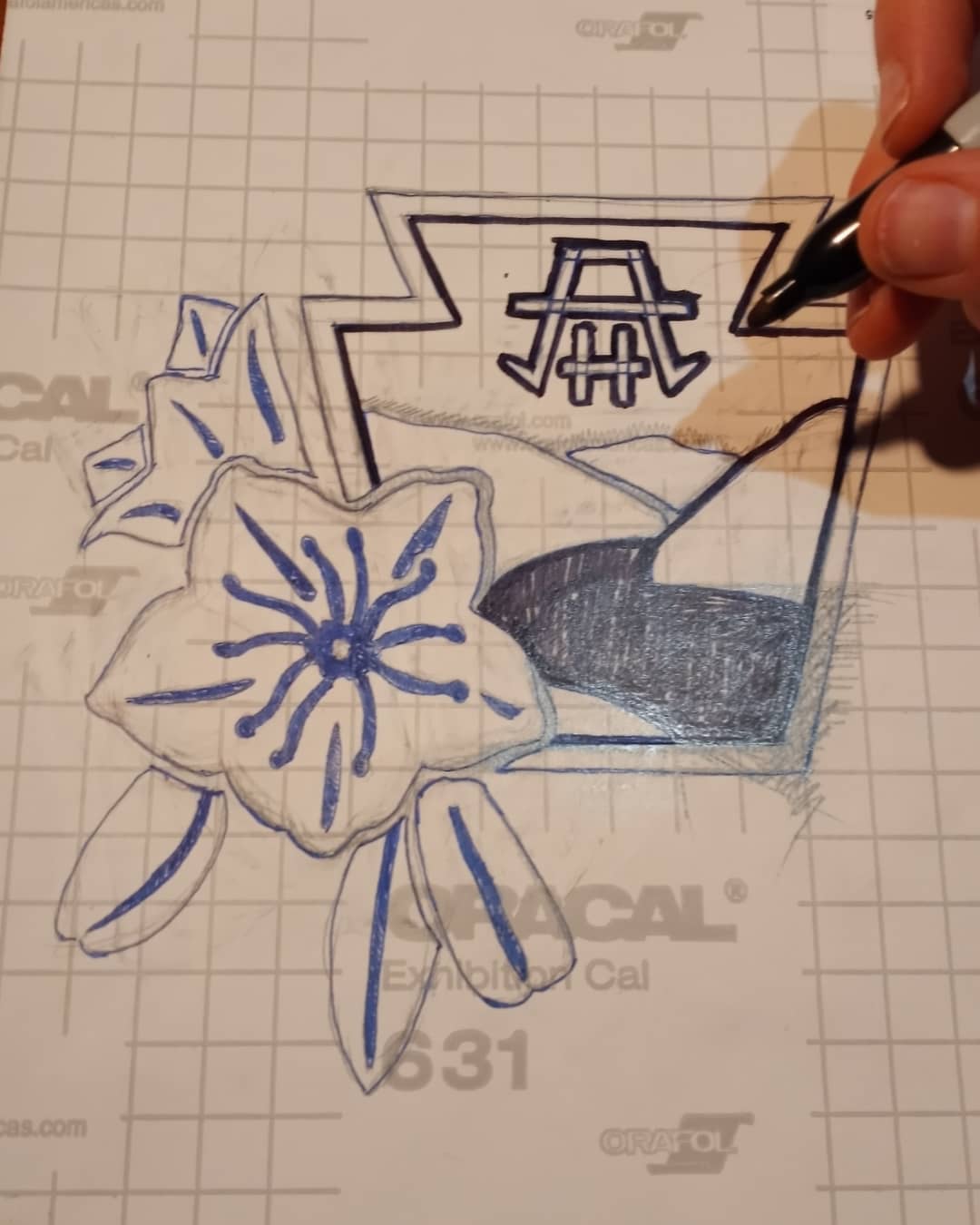 Artist designing a floral vinyl decal on graph paper.