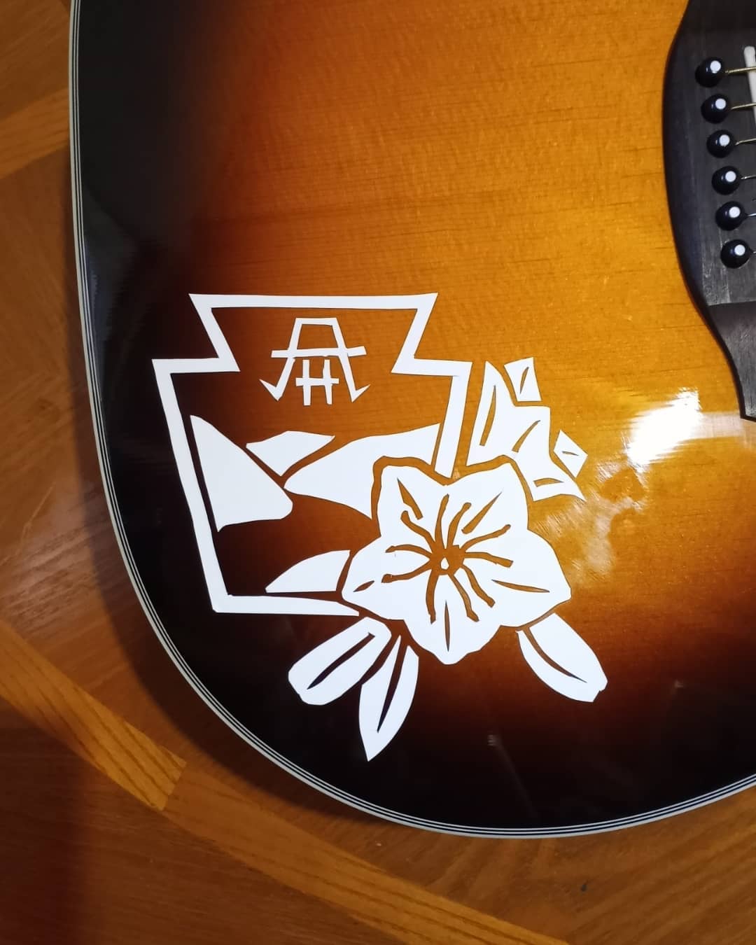 A custom vinyl decal on an Orangewood Echo Vintage Live acoustic guitar.