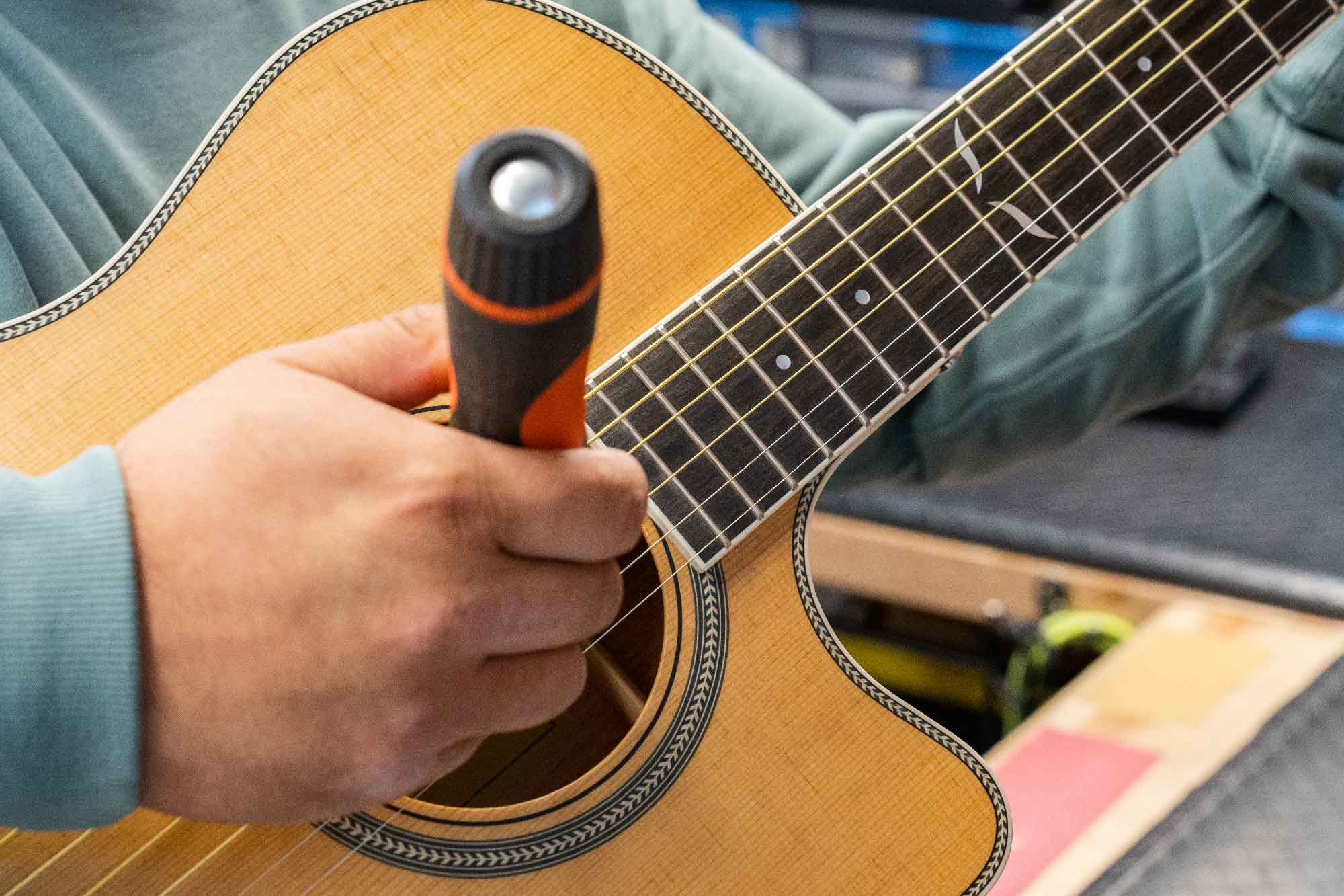 Photo of a truss rod adjustment on an acoustic guitar