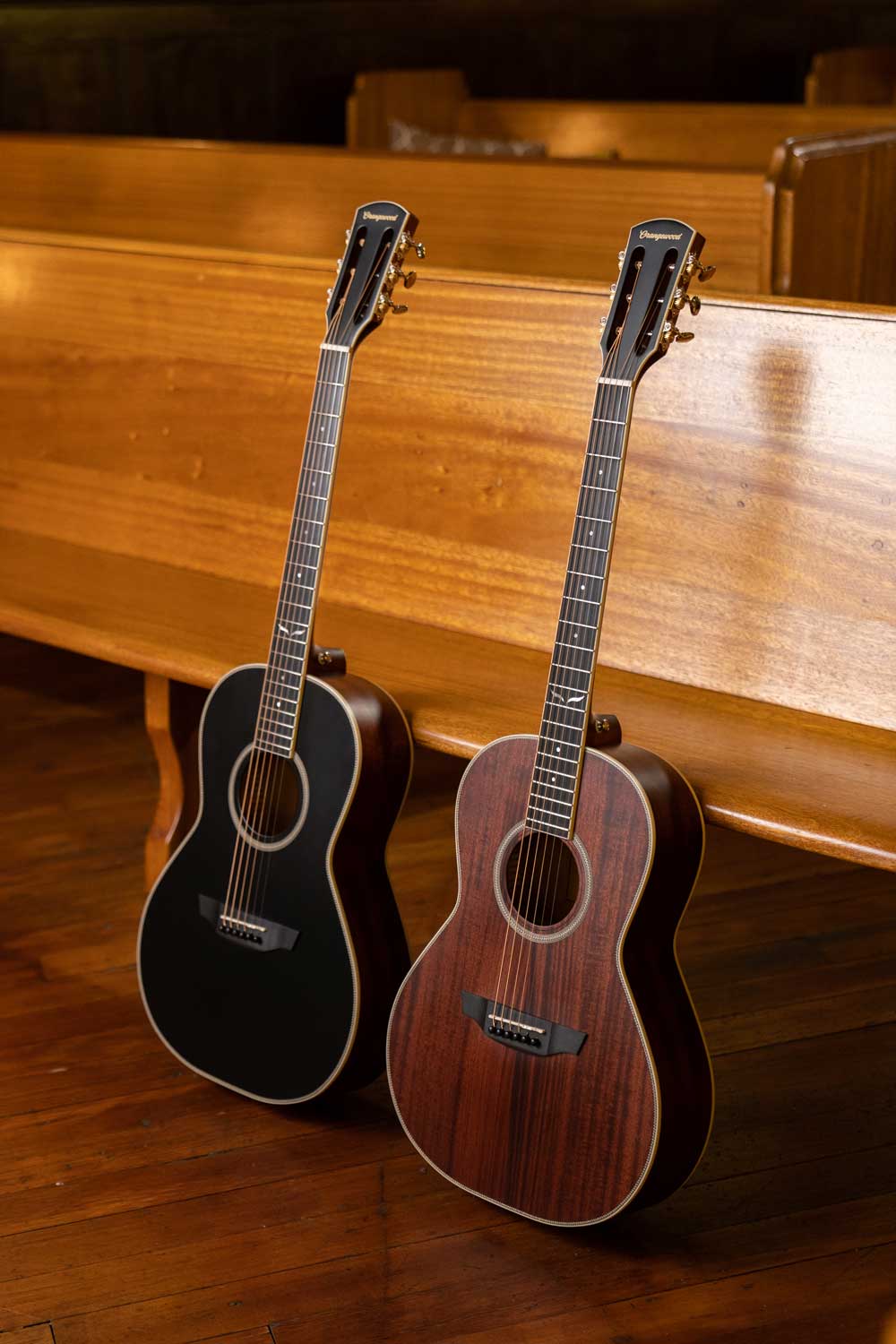 Two parlor guitars with slotted headstocks: one mahogany and one black