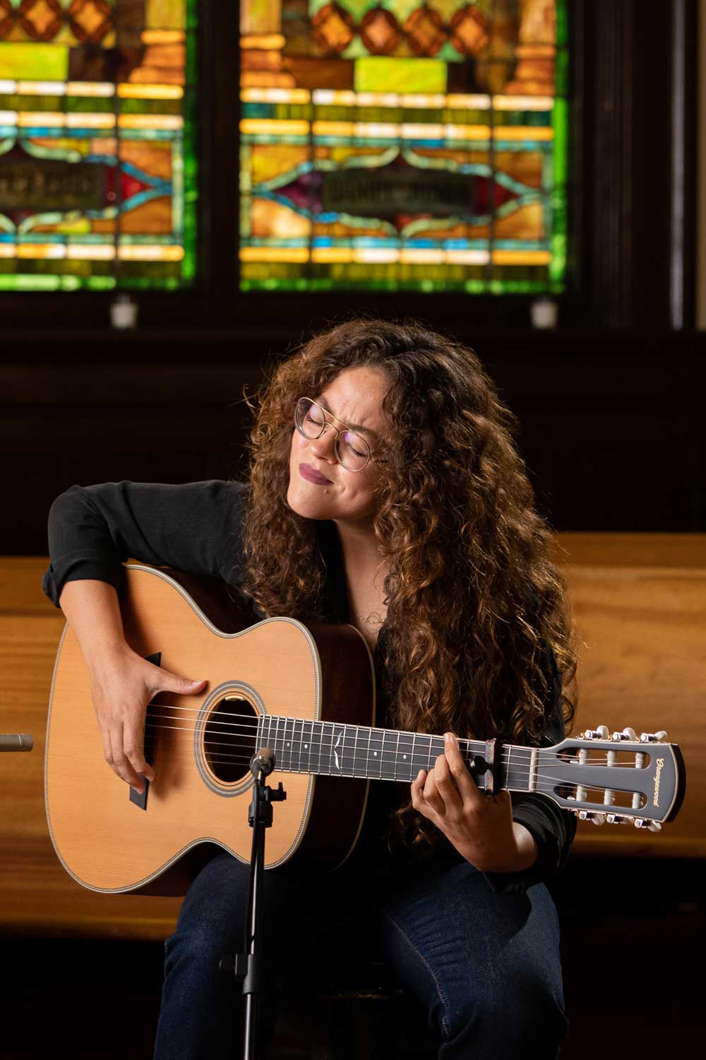 A woman passionately plays a classical nylon string guitar