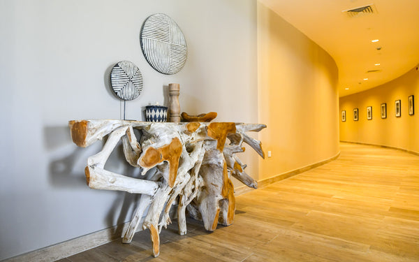 A natural live edge root table console with some decor on it