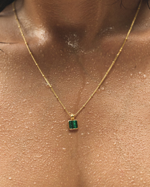 close up on malachite necklace worn at the beach