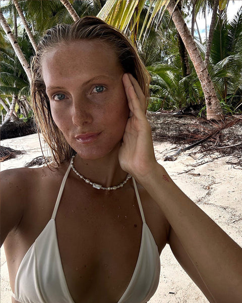 girl in cream bikini and pearl necklace