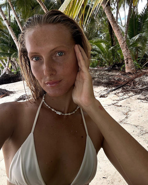 girl wearing pearl choker and beige bikini outfit