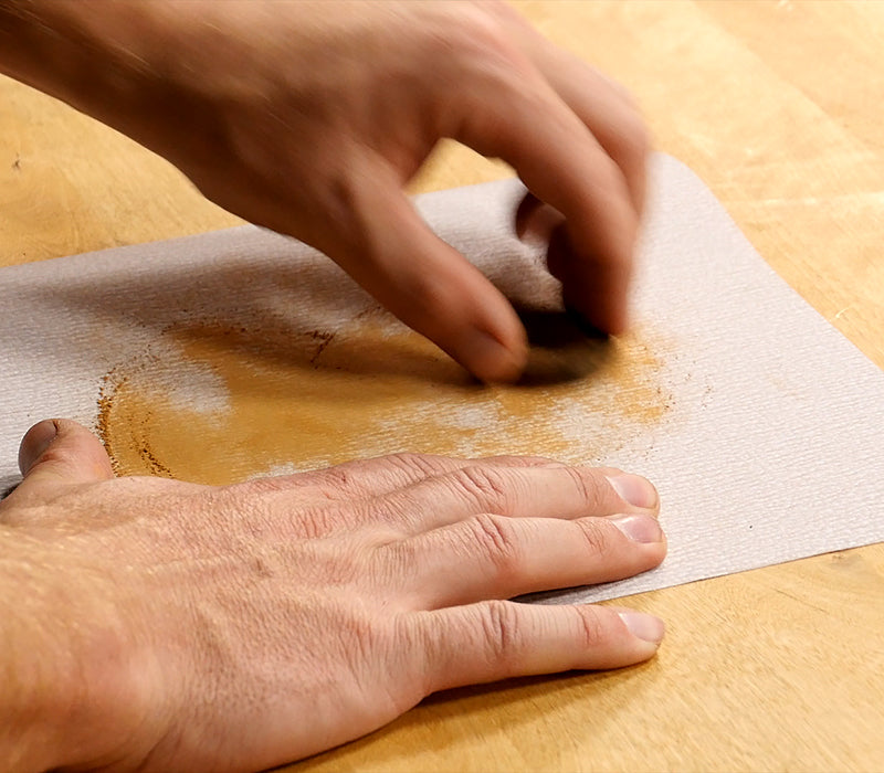 Sanding the blank on a flat surface.