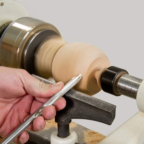 Shaping the snowman base with a spindle gouge.