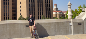 Caprock Skateboards Founder Alec Benton holding Caprock Skateboard and wearing New WRLD t-shirt