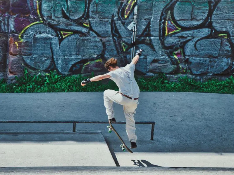 Skateboarder ollying onto platform in front of graffiti wall