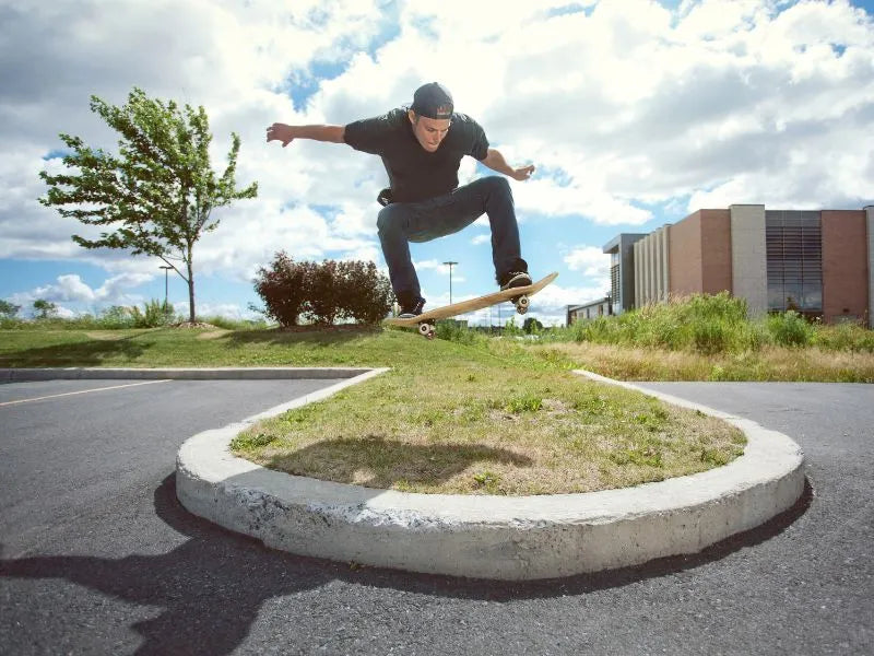Skater ollieing over grass obstacle