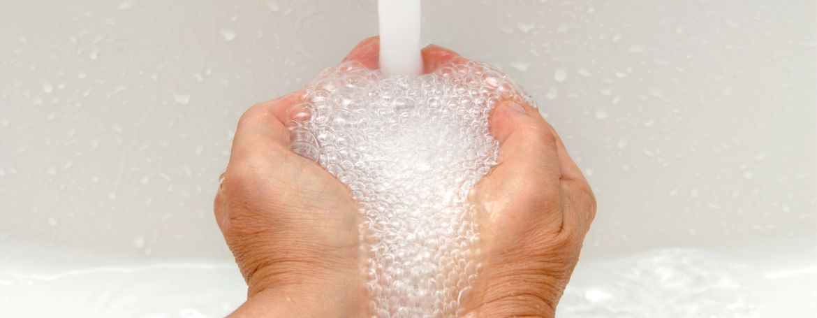 Hand holding soap bubbles from Yaye hand wash – soft, foamy lather from plant-based ingredients supporting skin hydration and hygiene.