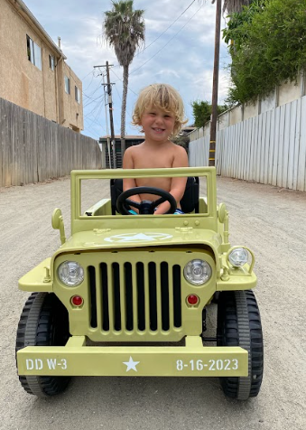 toddler riding the vintage military jeep in olive