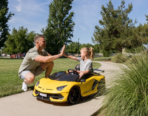 Parent and child riding the 24V Lamborghini Aventador Drift Car