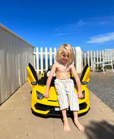 Child leaning on the Lamborghini electric kid car power wheels