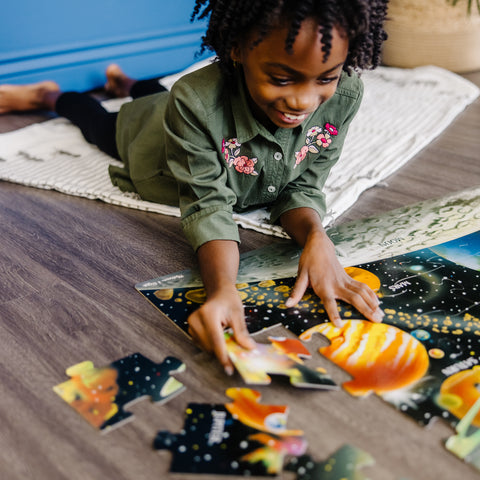 Girl playing with Melissa & Doug floor puzzle