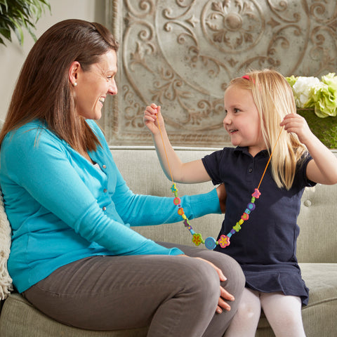 Girl giving mom a necklace made from the Melissa & Doug Bead Bouquet bead set