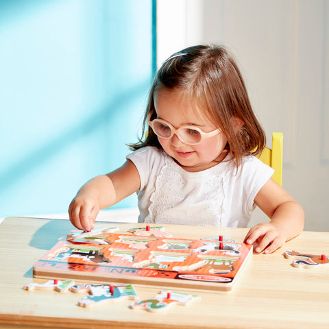 Girl playing with Melissa & Doug wooden puzzle