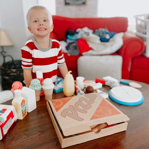 Boy playing with Melissa & Doug pizza and ice cream toys