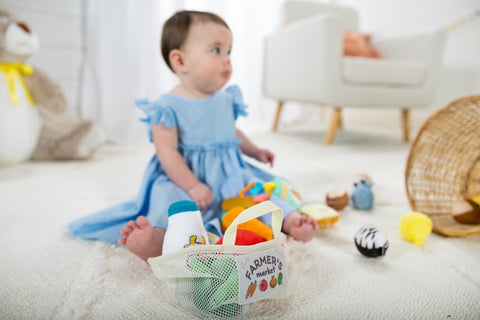 Baby girl playing with Melissa & Doug Market Basket Fill & Spill Toy