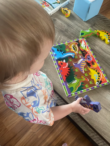 Girl playing with Melissa & Doug Chunky Dinosaur Puzzle